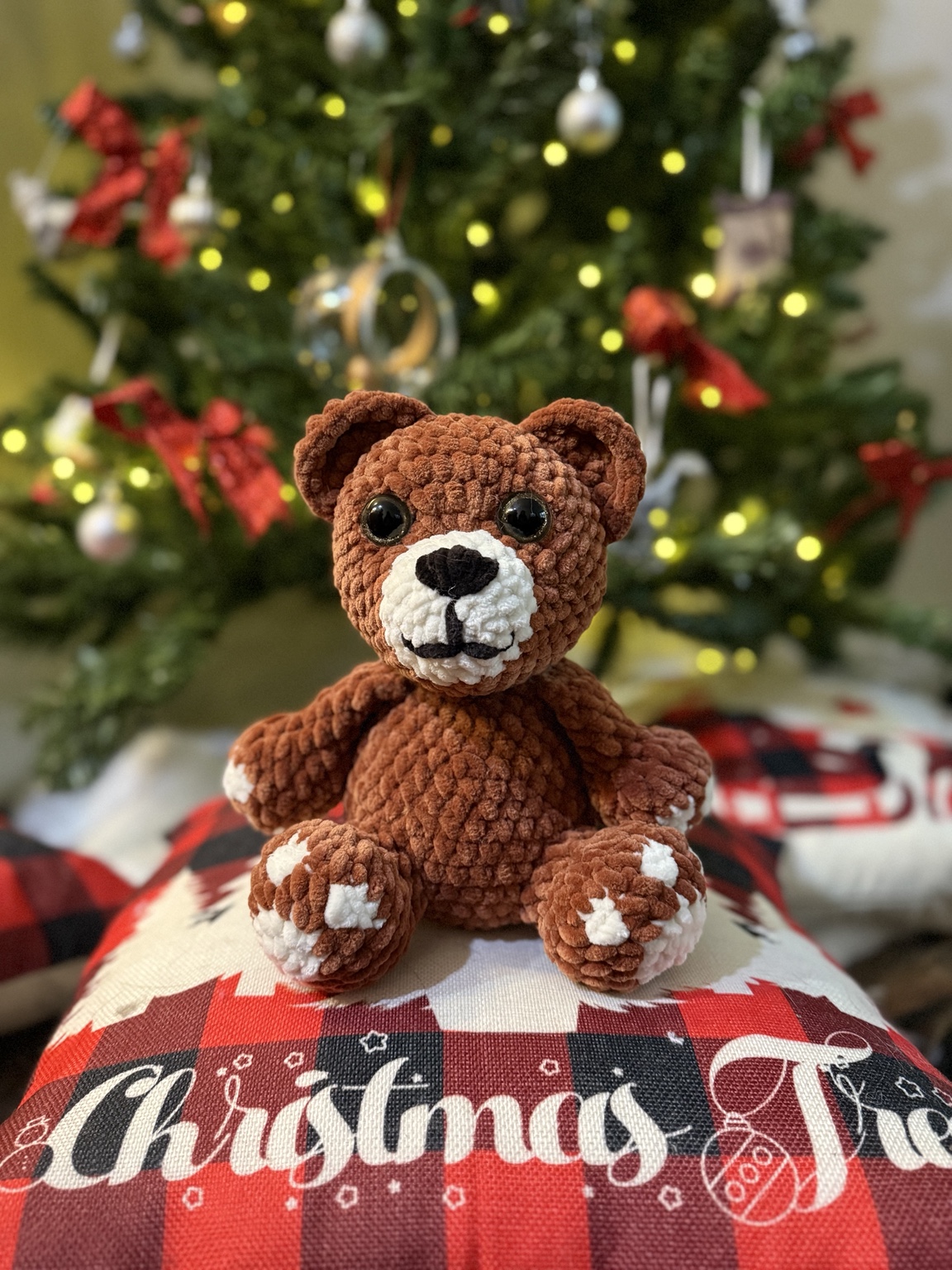 Brown crochet teddy bear with cream muzzle and paw details.